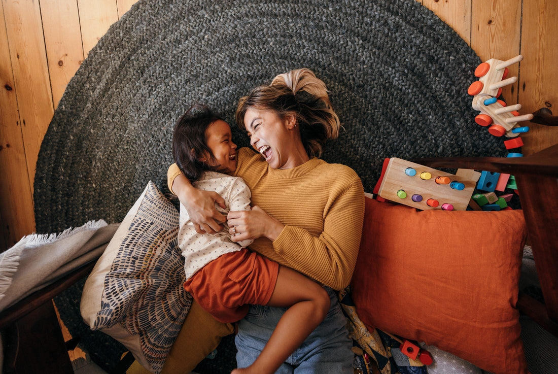 A parent and child laughing together while playing